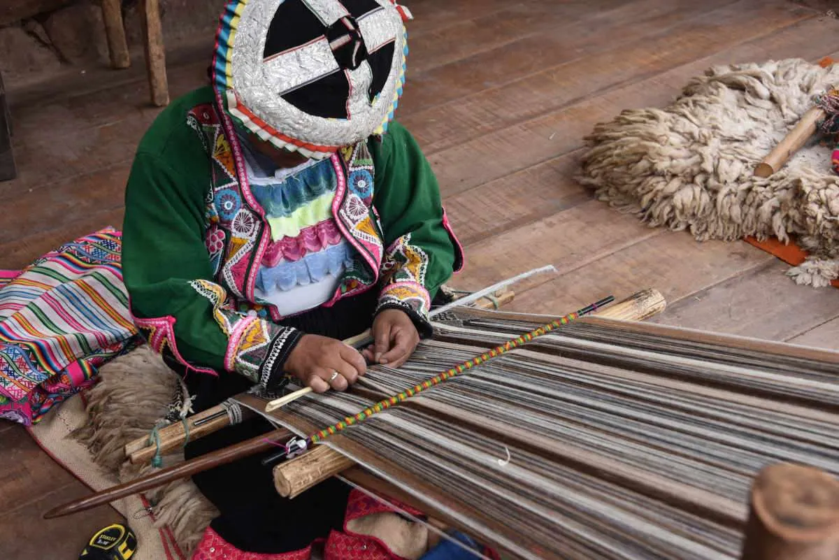 पारंपरिक बुनाई तकनीकों का प्रदर्शन करती क्वेशुआ महिला