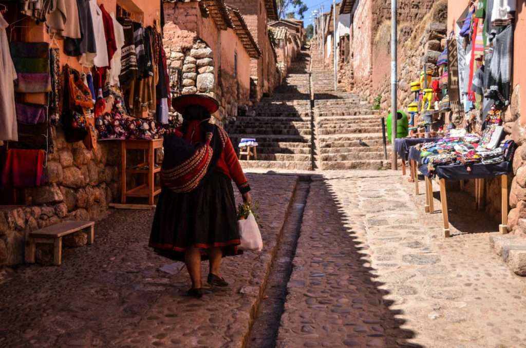 Woman in traditional Peruvian clothings walking in Chinchero